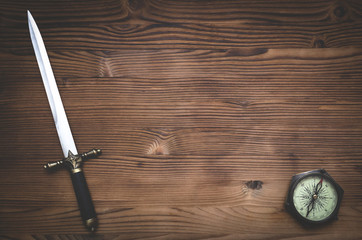 Travel or adventure flat lay background with copy space. Adventurer table. Compass and a dagger...