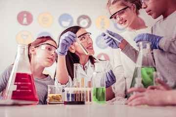 Curious children in protective glasses following their teacher