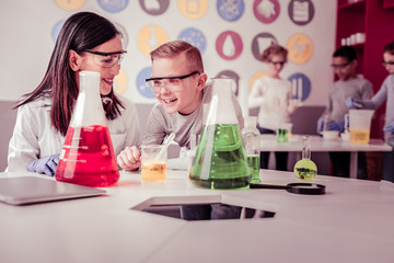 Beaming teacher explaining her interested schoolkid aspects