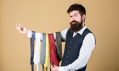 This tie is a must have. Brutal hipster holding colorful tie collection. Bearded man choosing neck...