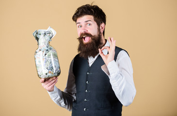 Getting rich. Rich businessman gesturing ok with money in glass jar. Bearded rich man with money cash. When become a rich man never trust a banker