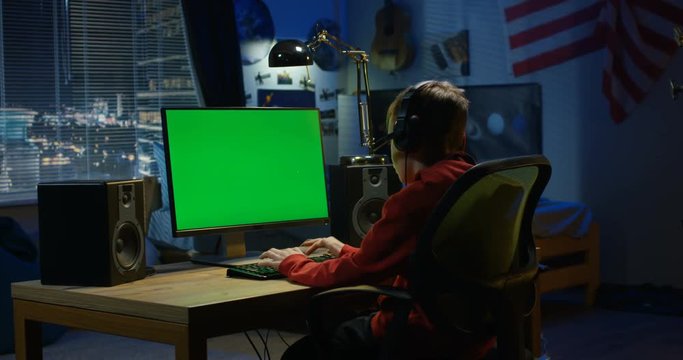 Boy using his computer at night