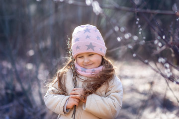  little girl with sprigs of willow in the forest in spring