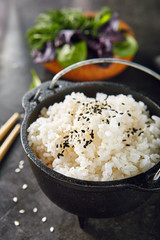 Heap of Cooked Boiled Round White Rice in Metal Bowler. Steamed Cereal with Sesame Seeds on Natural...