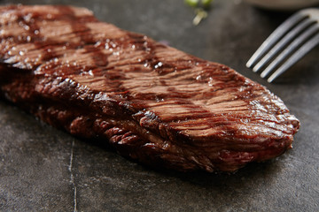 Hot Grilled Whole Denver Steak on Black Stone Background