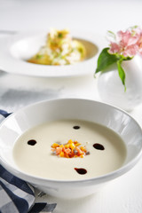 White Cream Soup with Pumpkin and Salmon on Blurred Background