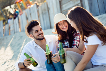 Group of young friends laughing and drinking beer