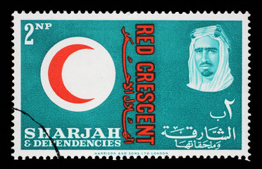 Stamp issued in the Sharjah shows Red Crescent Emblem, portrait of Sheik Saqr bin Sultan al Qasimi, 100 years International Red Cross, circa 1963.