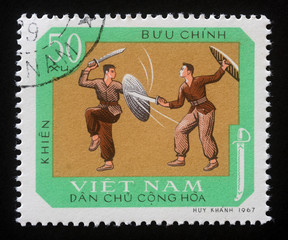Stamp printed in Vietnam shows Duel with sword and shields, traditional national sport, circa 1968.