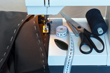 Sew at home. Processing the bottom of the  trousers on the sewing machine. Sewing accessories:...