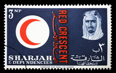 Stamp issued in the Sharjah shows Red Crescent Emblem, portrait of Sheik Saqr bin Sultan al Qasimi, 100 years International Red Cross, circa 1963.