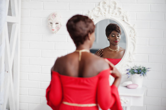 Fashion African American Model In Red Beauty Dress, Sexy Woman Posing Evening Gown And Looking At Mirror.