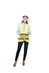 Full length view of smiling engineer in safety vest and hardhat isolated on white