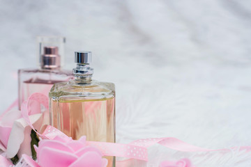 Obraz na płótnie Canvas Bottle of perfume with flowers on white fluffy background