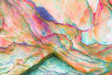 Multicolored rock wall from bottom sediments red orange dark rays crack smooth