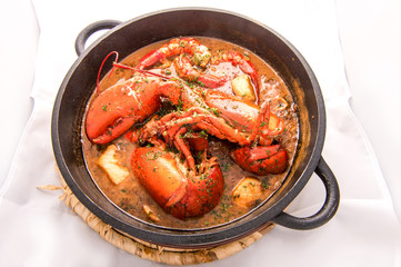Traditional spanish paella rice with lobster and meat on pan