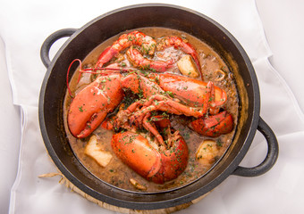 Traditional spanish paella rice with lobster and meat on pan