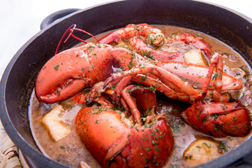 Traditional spanish paella rice with lobster and meat on pan