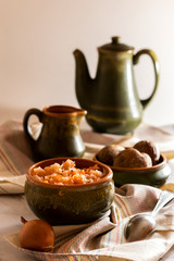 sauerkraut with boiled potatoes in earthenware on a light background