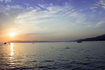 Bright sunset with large yellow sun under the sea surface, the image does not focus and blurred