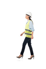 Side view of engineer in safety vest and high-heeled shoes walking isolated on white