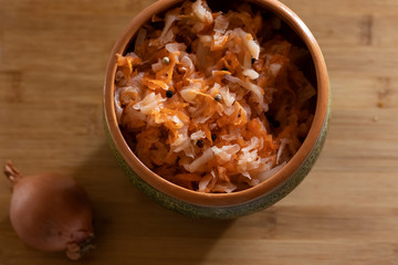 sauerkraut on a cutting board in pottery and light background