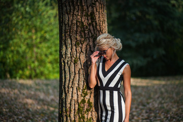 beautiful blonde woman in the autumn forest at sunset