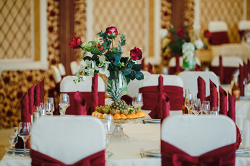 Table of fruit and crystal glasses arranged on a table. with red napkins.