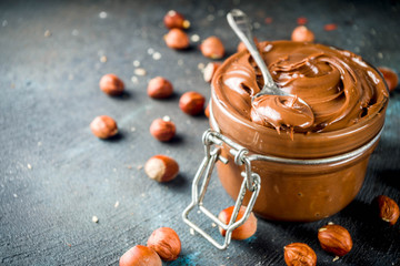 Breakfast confectionery and sweets concept. Homemade hazelnut chocolate spread in glass bowl with...