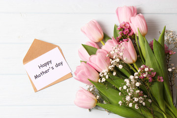  Beautiful composition for the Day of Mother on wooden background top view. Flowers, greeting card, gift.