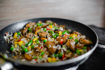 Fried frozen vegetable with rice and see food. Food remains in a black frying pan