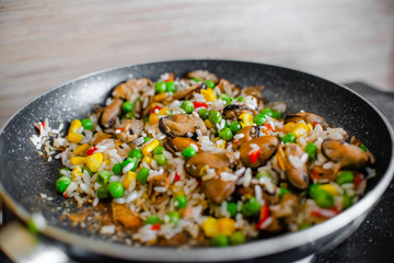 Fried frozen vegetable with rice and see food. Food remains in a black frying pan