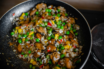 Fried frozen vegetable with rice and see food. Food remains in a black frying pan