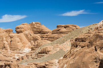Fototapeta na wymiar high rocky mountains in the desert against the blue sky and white clouds in Egypt Dahab South Sinai