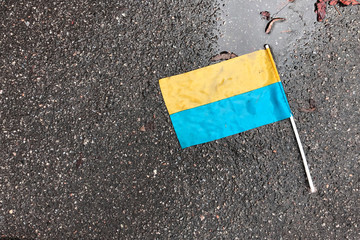 Fototapeta na wymiar Ukrainian flag is lying on the aspalt