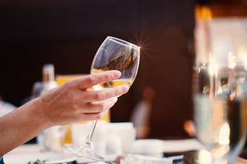 Glass of white wine in a womans hand