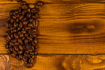 Pile of the coffee beans on wooden table. Top view