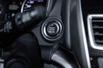 Obraz premium Сlose-up of the car grey interior: start stop engine button.