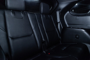 Obraz premium Сlose-up of the car black interior: black leather rear seats and seat belts .