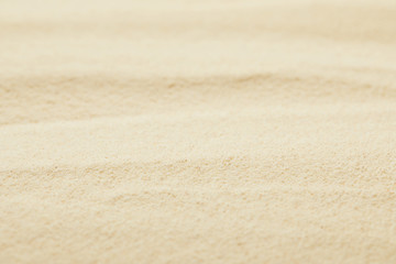 Fototapeta na wymiar selective focus of golden sandy surface on beach in summertime