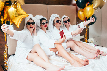 Bathrobe party girls taking selfie. Females leisure and lifestyle. Sunglasses and towel turbans on....