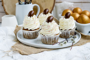 Carrot Easter cupcakr with chocolate egg on top and whipped cream frosting close up seective focus