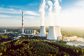A Power plant with white smoke over it's chimneys