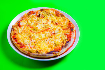 hot tasty fresh pizza on a plate close-up. green background