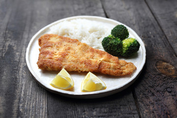 Cod fillet fried with rice and broccoli.