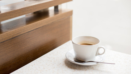 White cup of coffee with milk on light background in the cafe