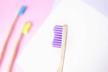 Violet bamboo toothbrush. Eco-friendly concept. Minimal, colored geometric background. Top view, copy space