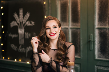 Portrait of a beautiful brunette with curls and red lipstick