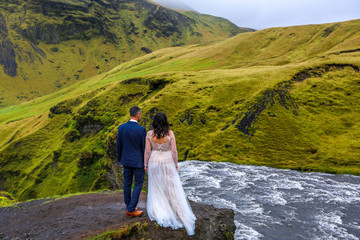 Beautiful wedding couple posing with waterfall