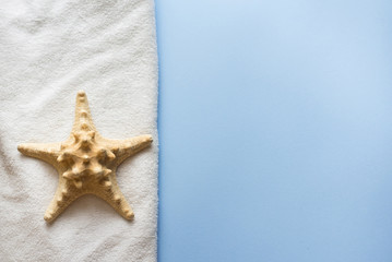 Fototapeta na wymiar sea star and towel for bath and spa on blue background. body skin care concept . copy space